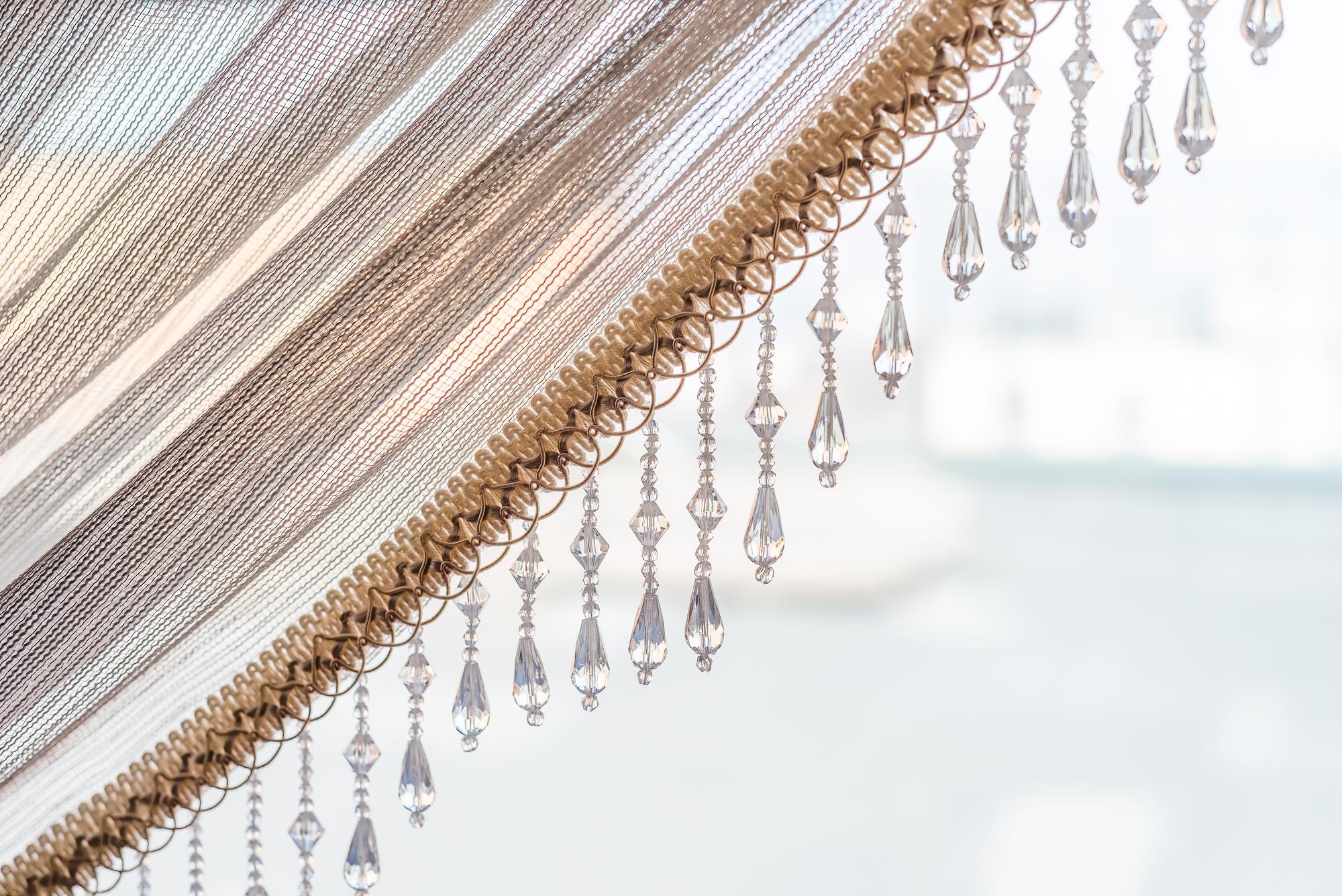 Embroidered curtain panel on a wooden rod